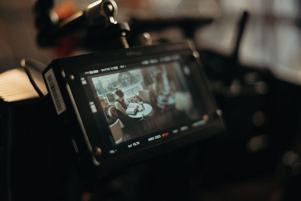 a camera's display screen showing people sitting around a table