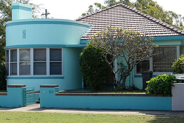 Art Deco a light blue art deco home with a green yard